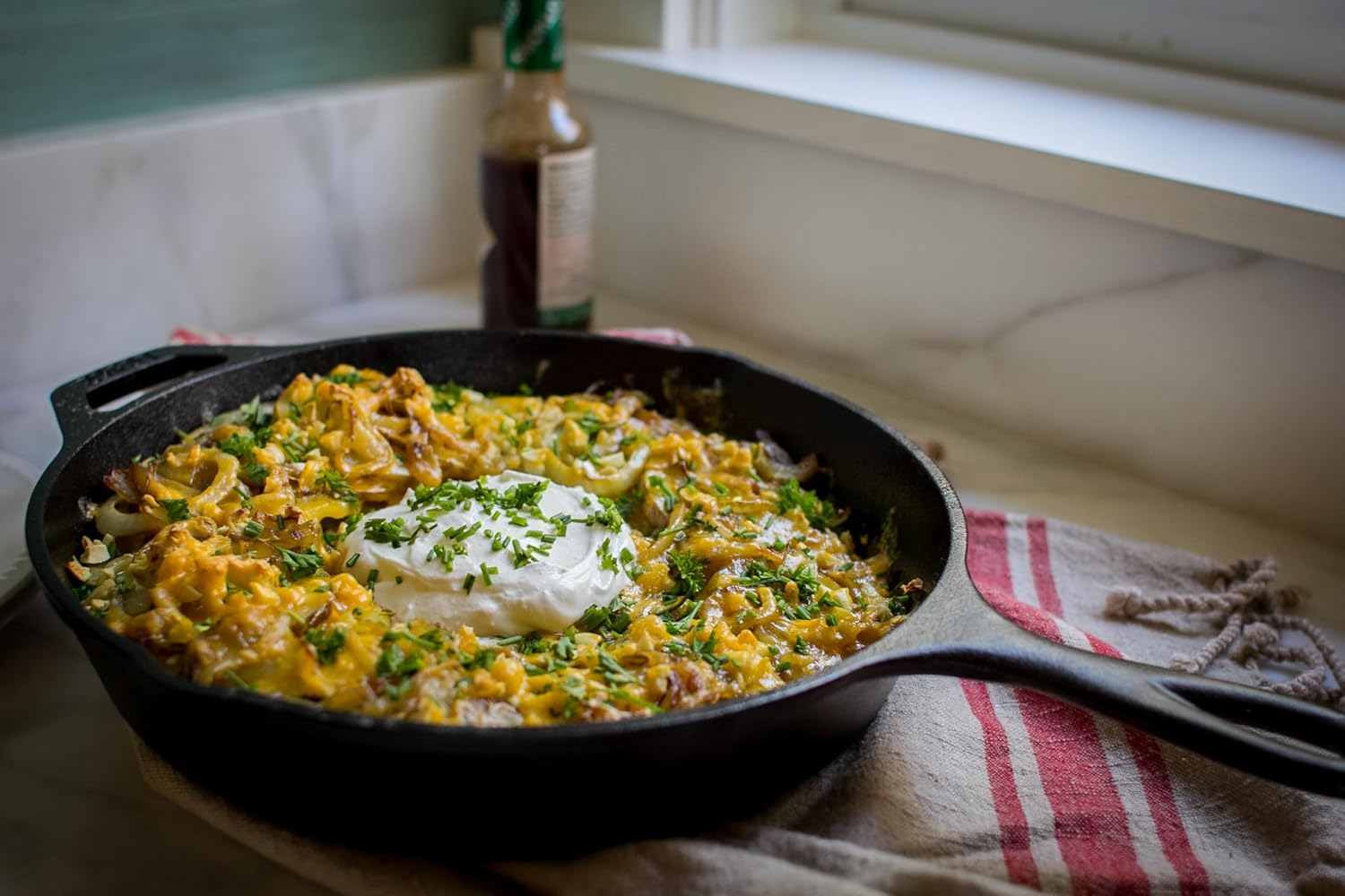 Lodge cast iron skillet with a baked casserole showing the heavy thermal mass and oven-to-table versatility